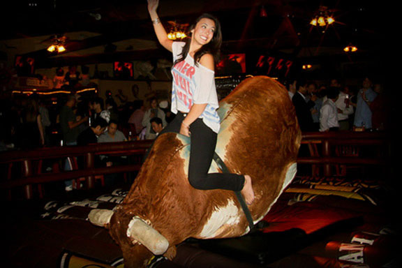 Photo of a woman riding our mechanical bull